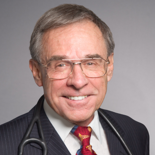 A portrait of a man wearing glasses, a checkered shirt, and a maroon v-neck sweater vest.