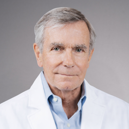 A portrait of a man wearing a white lab coat over a light blue shirt, with gray hair and blue eyes, looking directly at the camera.